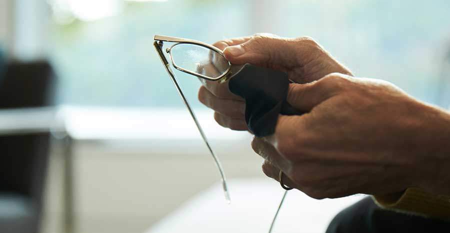 Man cleaning his glasses